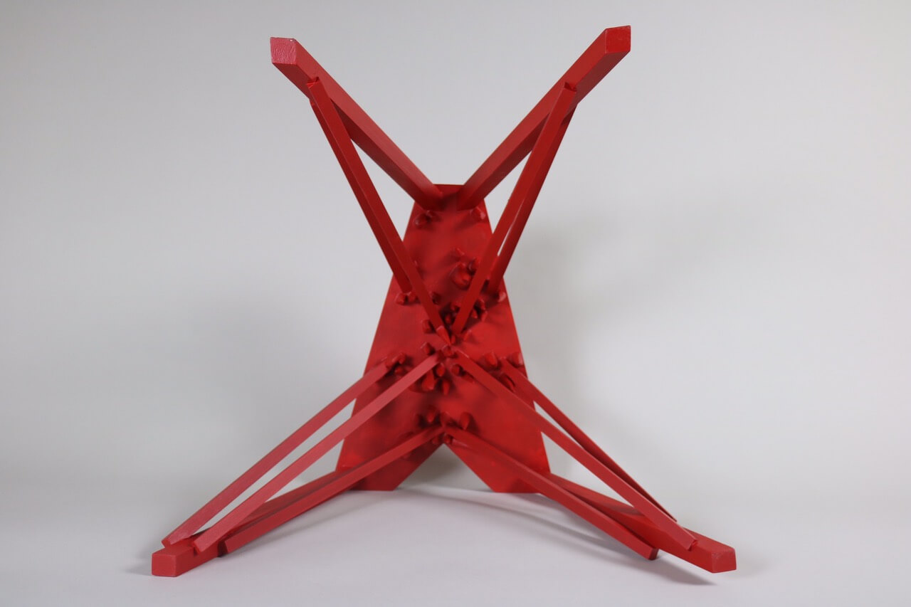 red wooden stool, with spikes underneath, from underneath